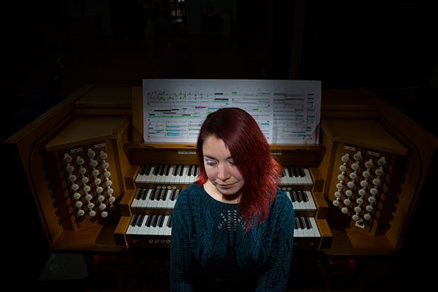 Dr Lauren Redhead, sat in front of organ keyboard