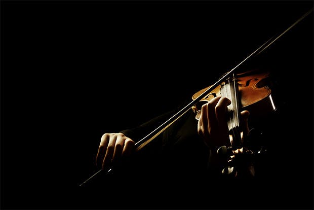 Violin player emerging from the dark