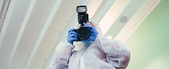 Social Sciences - About Us - Criminology Image 341x139 - Man in a crime scene suit with a camera