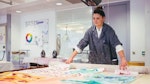 A student looking at pieces of textile design work on a table