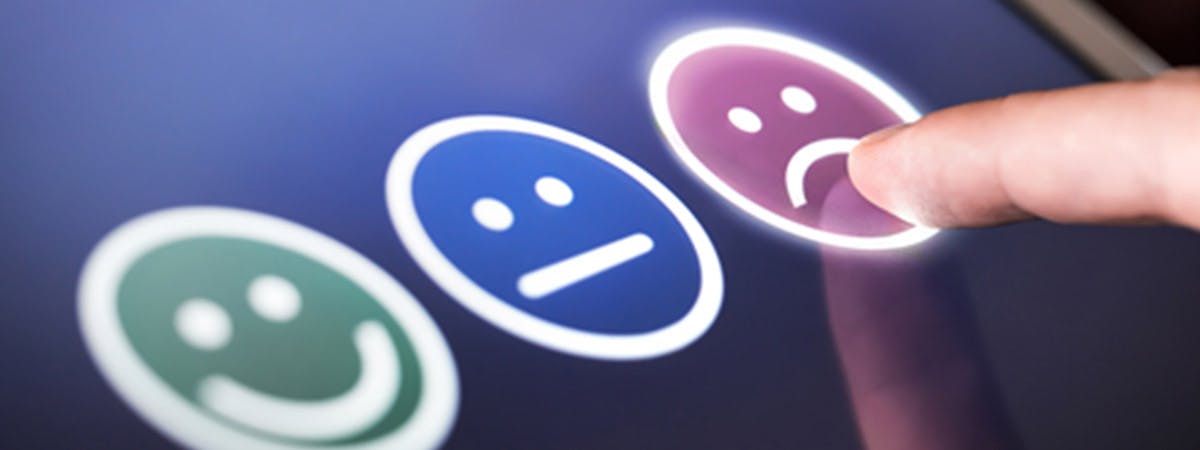 Three emojis - happy, middling and sad - on an iPad. 