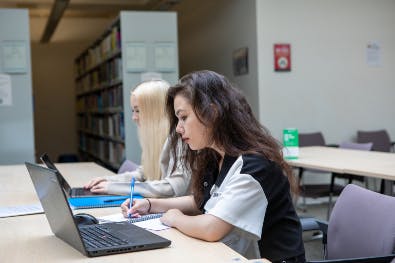 Students using laptops in the library
