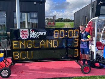 BCU Men's Football team captain Liam Davies pictured with the scoreboard at St George's Park after a 3-3 draw with England's National Cerebral Palsy Team.