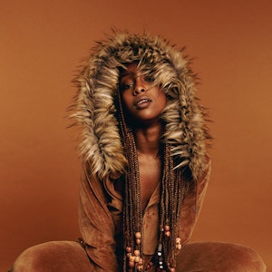 Artistic photograph of a woman with dreadlocks and fur hood and boots