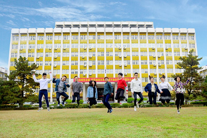 Students jumping outside main campus building