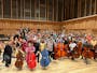 Children posing with mini-basses on the Bradshaw Hall Stage with Tony Alcock and Claus Freudenstein
