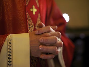 Bishop's hands clasped in prayer