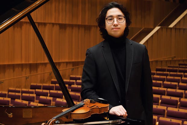 Violinist Can Cui standing next to piano