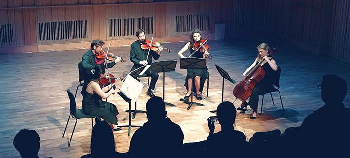 Students playing instruments at a chamber music performance