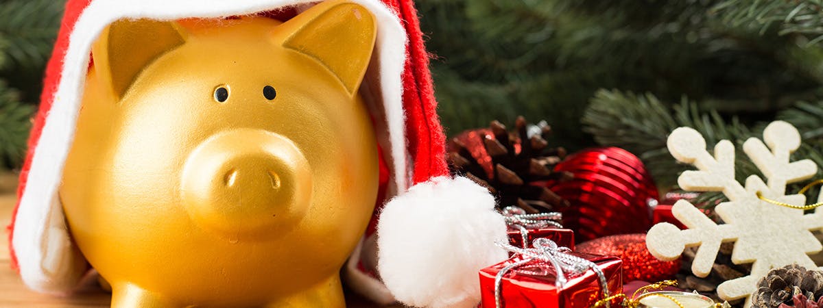 A piggy bank with a Christmas hat on
