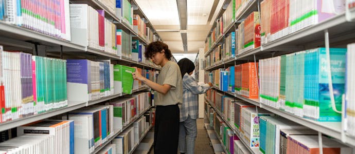 Students select books from the shelves at the Mary Seacole library at City South