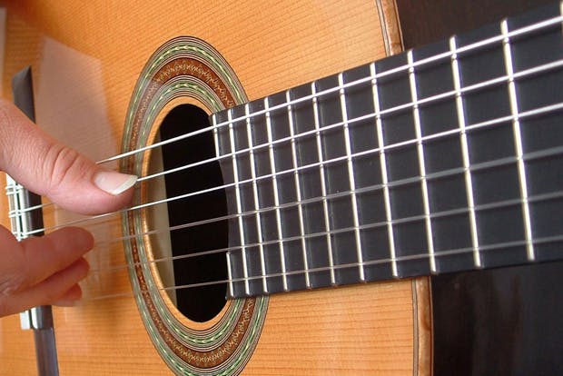 Close up of person playing classical guitar