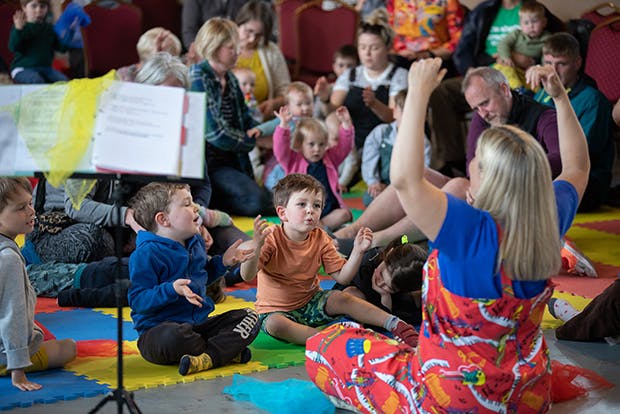 Toddlers enjoy music led by adult teacher