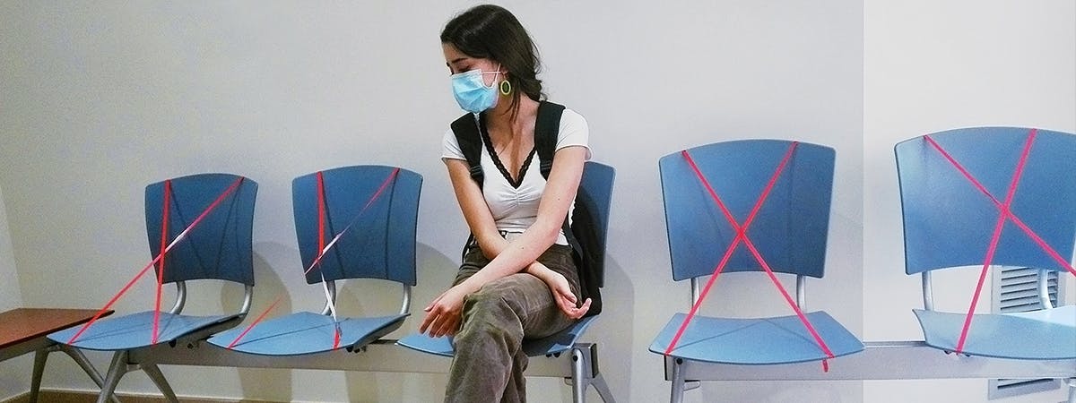 Young woman isolated in a waiting room during the coronavirus pandemic