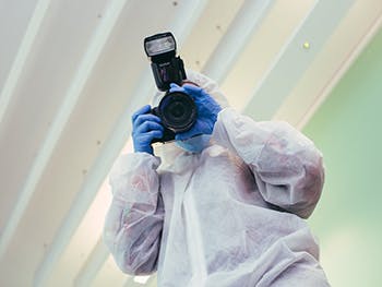 Criminology Course Image 350x263 - Person in a crime scene suit with a camera
