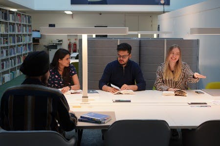 A group of students sat around a desk in Curzon Library