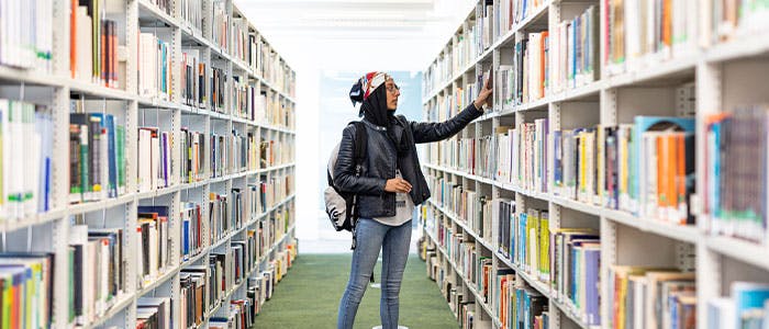 A student in the Curzon library browsing at books