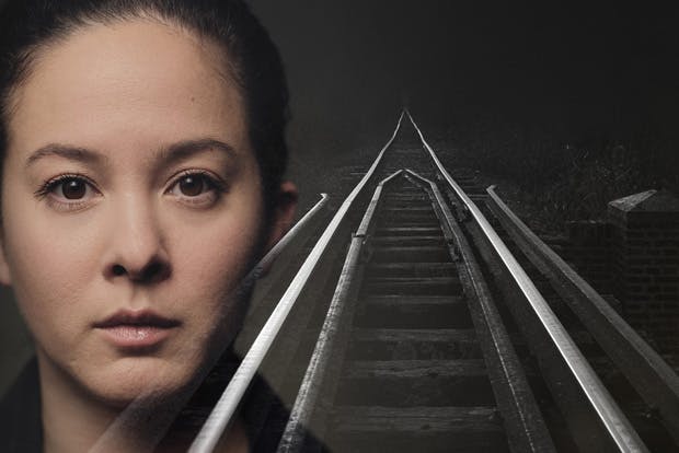 Woman's face superimposed over railway lines, single point perspective