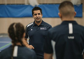 Dr Irfan Khawaja running a PE session in the sports hall with two students