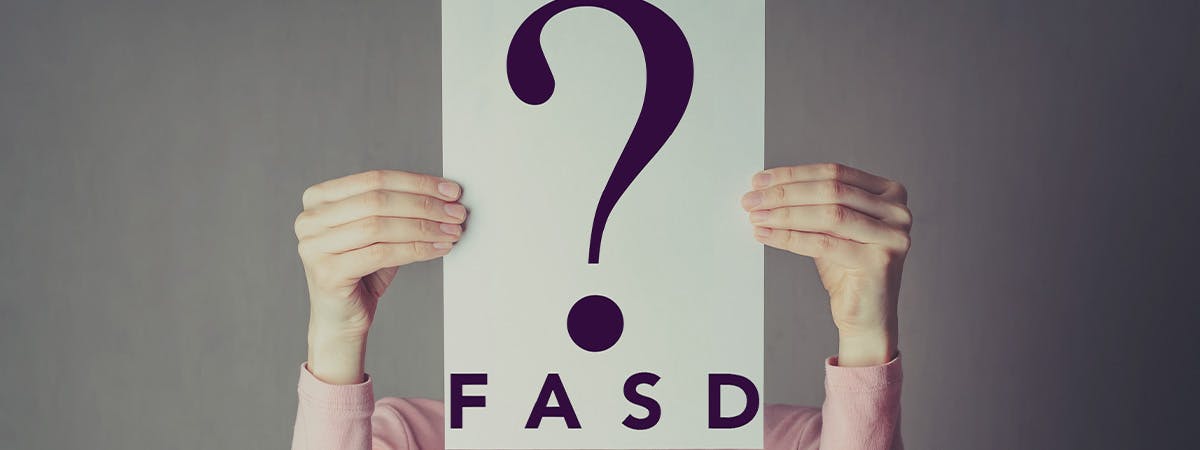 woman holding sign saying FASD?
