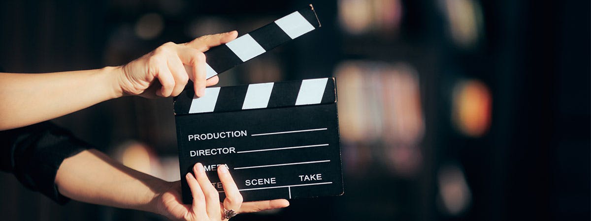 Hands Holding a Film Slate Directing a Movie Scene