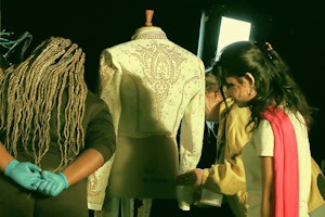 Students placing outfit onto mannequin 