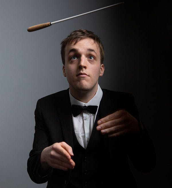 male throwing a conductors baton in the air