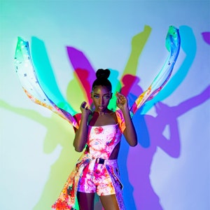 Model in butterfly style clothes in coloured light