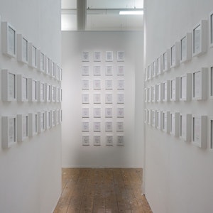 White wall corridor with lots of small white photo frames 