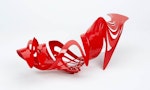 A red shoe made of plastic curves