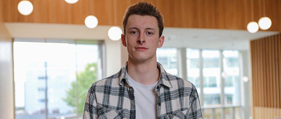 Acting student Matthew Underhill stood in Royal Birmingham Conservatoire atrium.