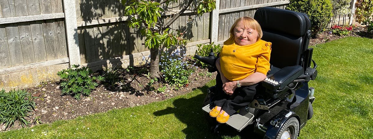 Kate Waugh, Head of Disability services in her electric wheelchair in the garden.