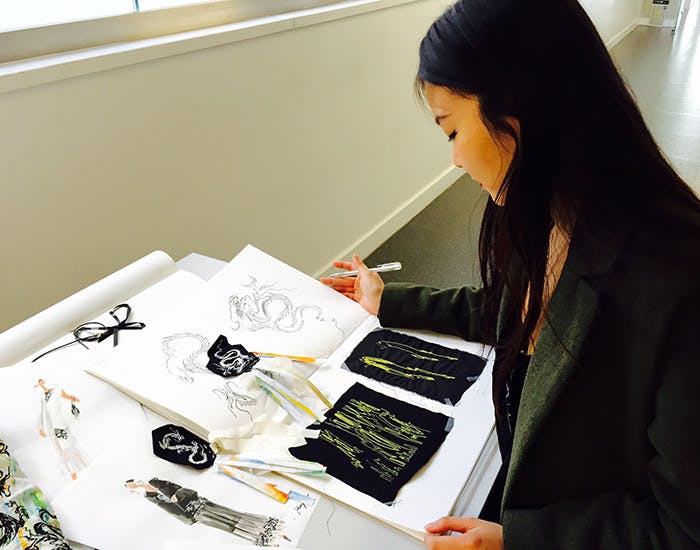 Mei-Sheng Sun working on her fashion designs