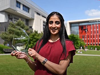 Photo of Asima outside BCU with Scholarship trophy in hand