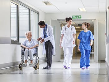 Doctor, nurses and patient in hospital corridor