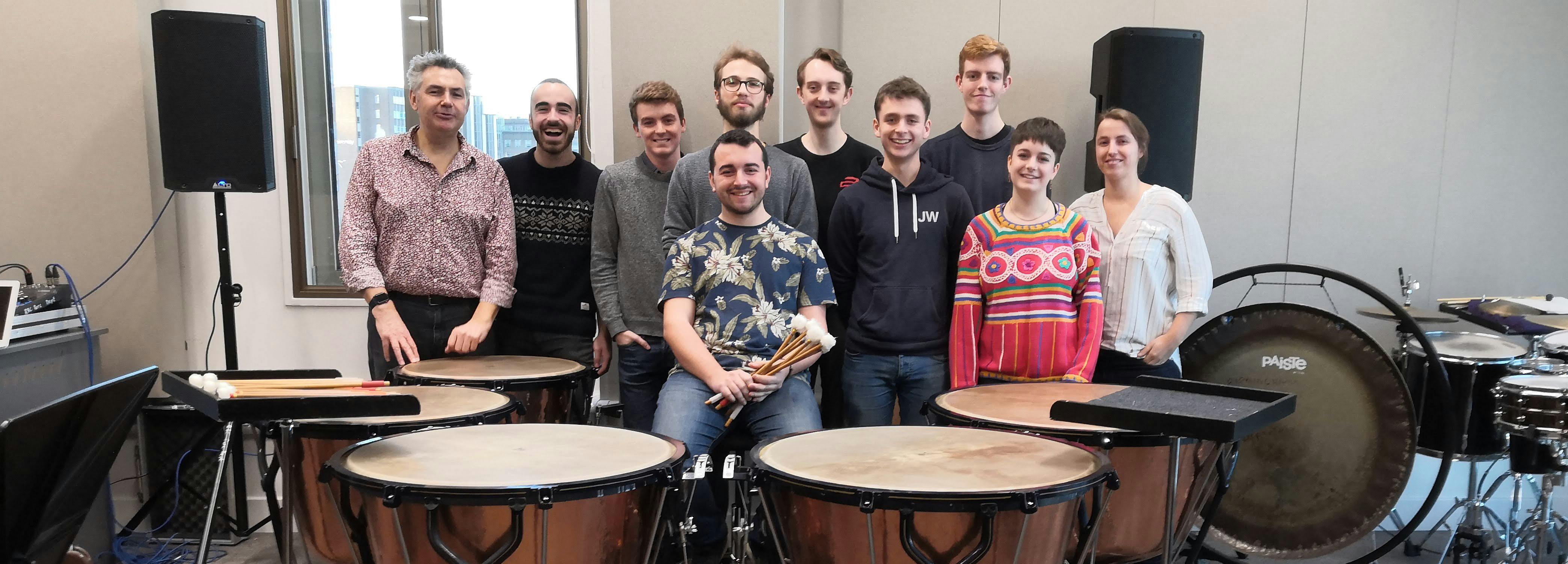 Opera timps masterclass with Dominic Hackett from ENO. Group of percussionists posing behind drums and speakers
