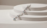 A silver chain with red and blue jewels