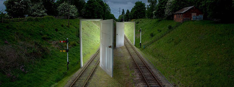 Photography piece of train lines with two open doors animated onto the track