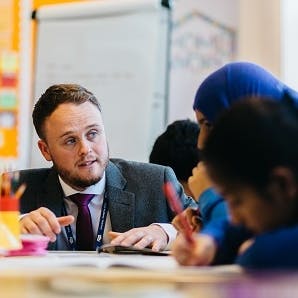 Graduate working with pupils in the classroom