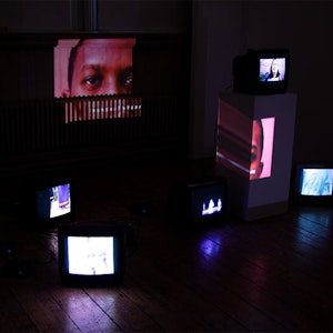 Fine Art installation: dark room with lots of old tv screens
