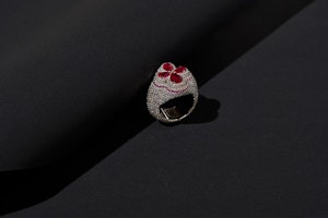 Silver bejewelled ring with red gem