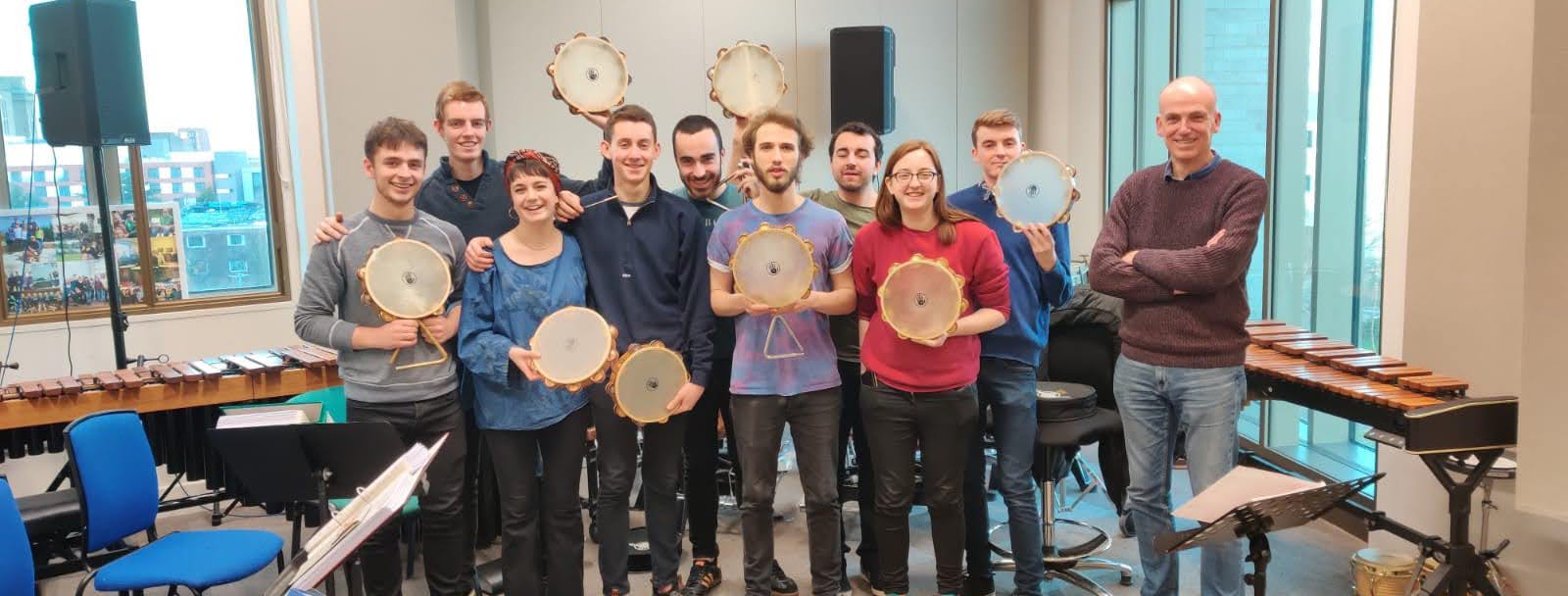 Tambourine masterclass with Jon Herbert . Group holding tambourines looking into camera and smiling