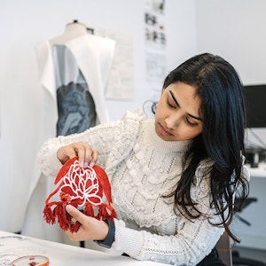 student holding up red textile design