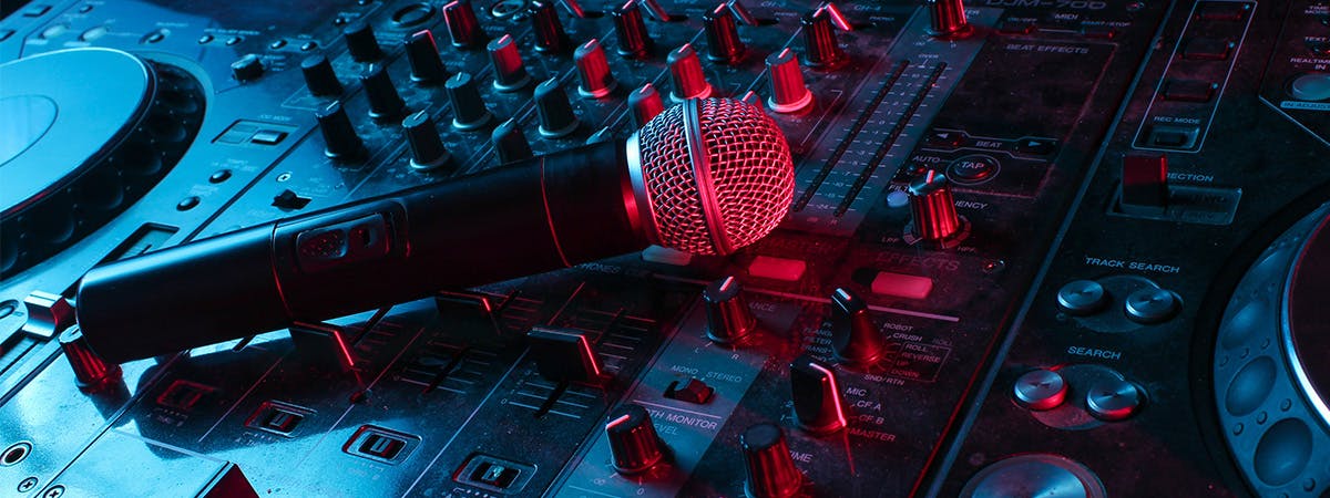A microphone resting on a mixing desk.